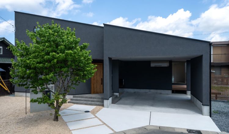 片流れの屋根に暗めのグレーの塗り壁がかっこいいお家 写真